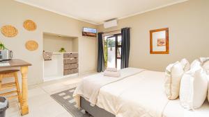 a bedroom with a bed and a table and a desk at Bosveld In Die Stad 2 Guesthouse in Alberton