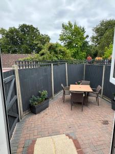 a patio with a table and chairs and a fence at Modern peaceful property Breakfast included in Blean