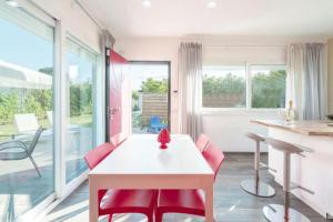 a dining room with a white table and red chairs at Villa by the sea - in full relaxation - Air conditioned - Wi-fi in Fontane Bianche