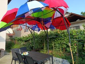 a table with colorful umbrellas on a patio at Kuća - Šekovići in Šekovići