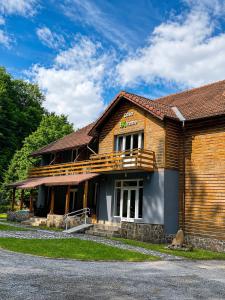 a wooden building with a sign on the side of it at Cabana Xtreme - Valiug in Văliug