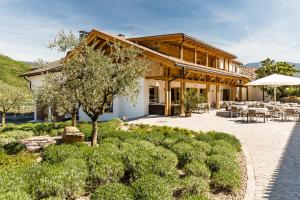 a house with a patio with tables and chairs at Pension Hasslhof in Caldaro