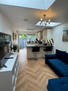 a living room with a blue couch and a kitchen at Modern peaceful property Breakfast included in Blean