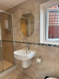 a bathroom with a sink and a shower and a mirror at Modern peaceful property Breakfast included in Blean +9 photos