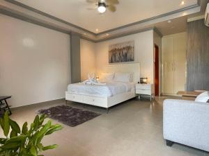 a bedroom with a white bed and a couch at Green Field Resort Hotel in Anda +15 photos