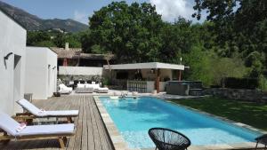 a backyard with a swimming pool and a wooden deck at Villa , Piscine Privée, Jacuzzi in Barbaggio