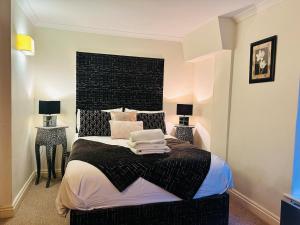 a bedroom with a large bed with a black headboard at Benson House Box in Box