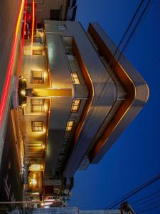 a tall building with lights on the side of it at ホテルリブマックスBudget川崎大師 in Kawasaki