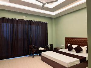 a bedroom with a bed and a table with a chair at Naman Eco Resort in Solan