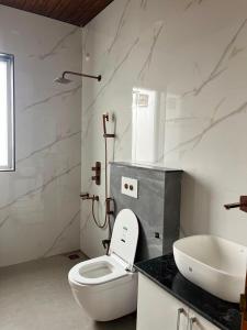 a bathroom with a white toilet and a sink at Naman Eco Resort in Solan