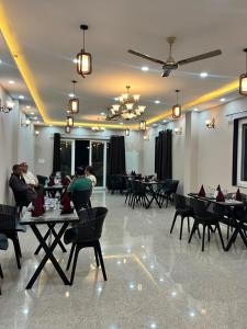 a restaurant with tables and chairs with people sitting at them at Naman Eco Resort in Solan
