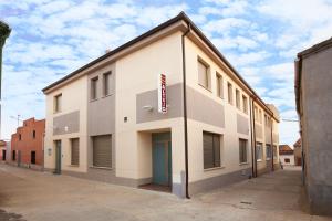 un bâtiment blanc avec un panneau sur son côté dans l'établissement Altejo, à Manganeses de la Lampreana