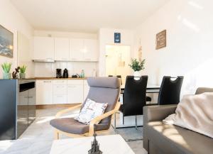 a living room with a chair and a kitchen at Terrassenhaus Whg 21 in Duhnen