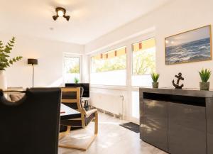 a living room with a fireplace and windows at Terrassenhaus Whg 21 in Duhnen +20 photos