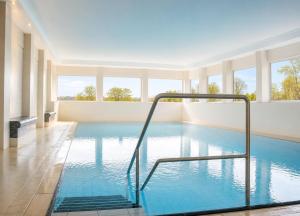 a large swimming pool with blue water in a building at Terrassenhaus Whg 21 in Duhnen