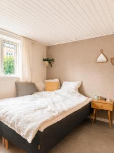 a large bed in a room with a window at Quiet and charming studio apartment in Vejle