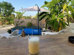 a drink on a wooden table with an umbrella at Casa Perico Reyes in Cartagena +25 photos