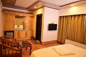 a bedroom with a bed and a table and a room at Hotel Baisaran Pahalgam in Pahalgām