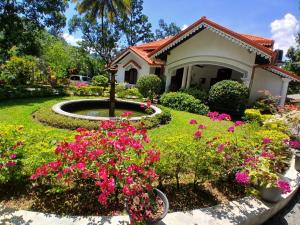 a house with a garden with flowers in the yard at Kithulvilla Holiday Bungalow in Kitulgala