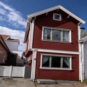 a red house with white windows on a street at Auntie Laurentze's house in Haugesund