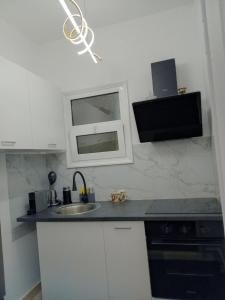 a kitchen with a sink and a window in it at Hera's apartment in Porto Rafti