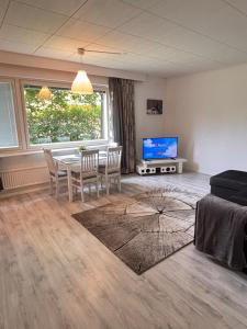 a living room with a table and chairs and a tv at Hamina Comfort Apartment in Hamina