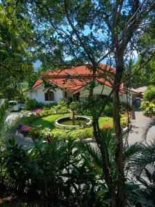 a white house with a red roof and a garden at Kithulvilla Holiday Bungalow in Kitulgala +56 photos