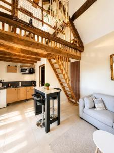a kitchen and living room with a table and a couch at Le Nid du Viaur in Pampelonne
