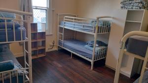 a room with two bunk beds and a window at 1849 Backpackers at The London in Albany