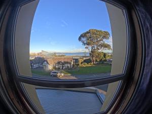 a view through a round window of a house at 1849 Backpackers at The London in Albany