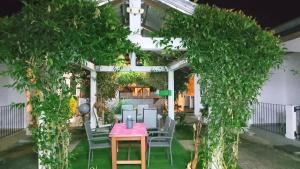 a patio with a table and chairs under a pergola at Résidence Merveilles P14 in Kribi