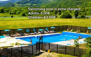 a swimming pool with umbrellas and people in it at Tara Holiday Home in Mojkovac