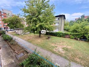 a yard with a tree and a building at SkyLux Premium Zenica in Zenica