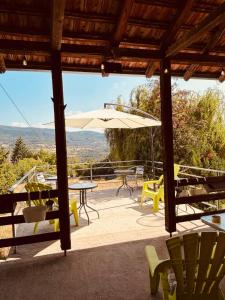 a patio with tables and chairs and an umbrella at Cottage House Official in Niš