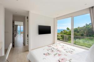 a bedroom with a bed and a large window at Mountain and Sea view apartment in Nathon Bay