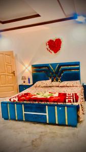 a bedroom with a bed with a heart on the wall at The Skyline Cottage in Nathia Gali +8 photos