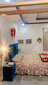 a bedroom with a bed and a table with a lamp at The Skyline Cottage in Nathia Gali