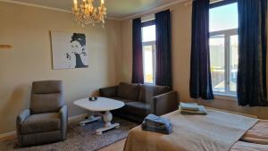 a living room with a couch and a table and chairs at Vårsol Overnatting i Vardø centrum in Vardø