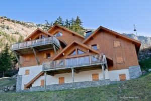 a large wooden house with two decks on a hill at LesChalets de Pré Genty in Oz