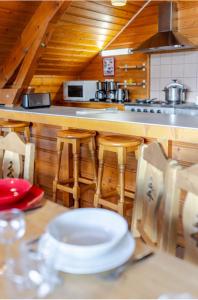 a kitchen with a table with chairs and a counter top at LesChalets de Pré Genty in Oz