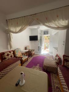 a living room with a couch and chairs and a table at بيت الضيافه و الترحيب in Azrou