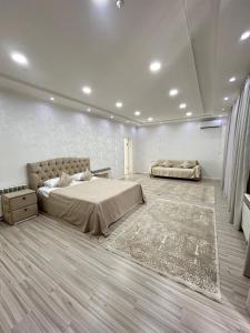 a large bedroom with a bed and a rug at Comfort Hotel in Türkistan