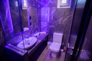 a purple bathroom with a sink and a toilet at Skyline suite studio in Larisa +29 photos