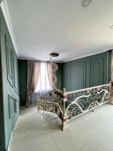 a room with a staircase with green walls and a window at Comfort Hotel in Türkistan