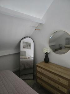 a bedroom with a mirror and a dresser and a bed at Cosy Moat House Cottage #2 in Pembroke