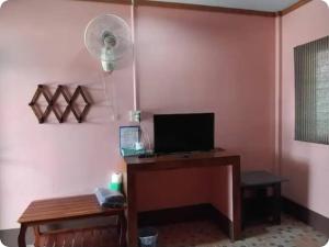 a room with a desk with a computer and a fan at Saran Resort room 1 in Ban Khok Wat