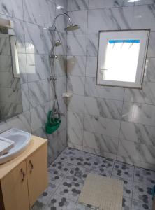 a bathroom with a shower and a sink at Résidence Merveilles P14 in Kribi