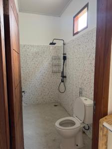 a bathroom with a toilet and a shower at JHOB Surf Stay in Maluk