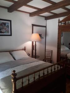 a bedroom with a bed with a lamp and a mirror at Gîte Le Pont du Soleil in Hyds