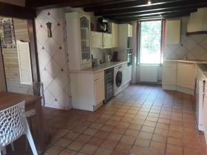 a kitchen with white cabinets and a tile floor at Gîte Le Pont du Soleil in Hyds +16 photos